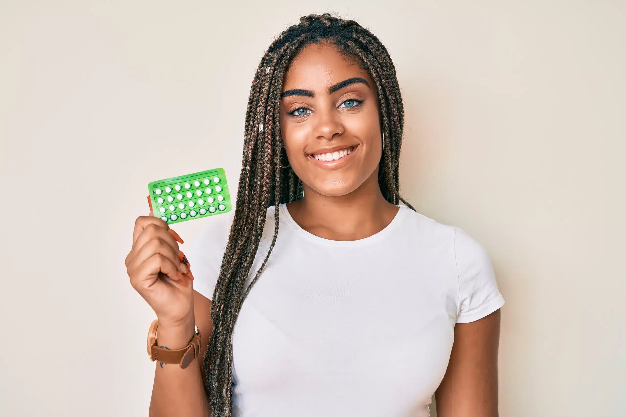 Woman holding a green pack of birth control pills, highlighting Gynecology Care and Reproductive Health Services at Seashore MD in Little Silver, NJ.