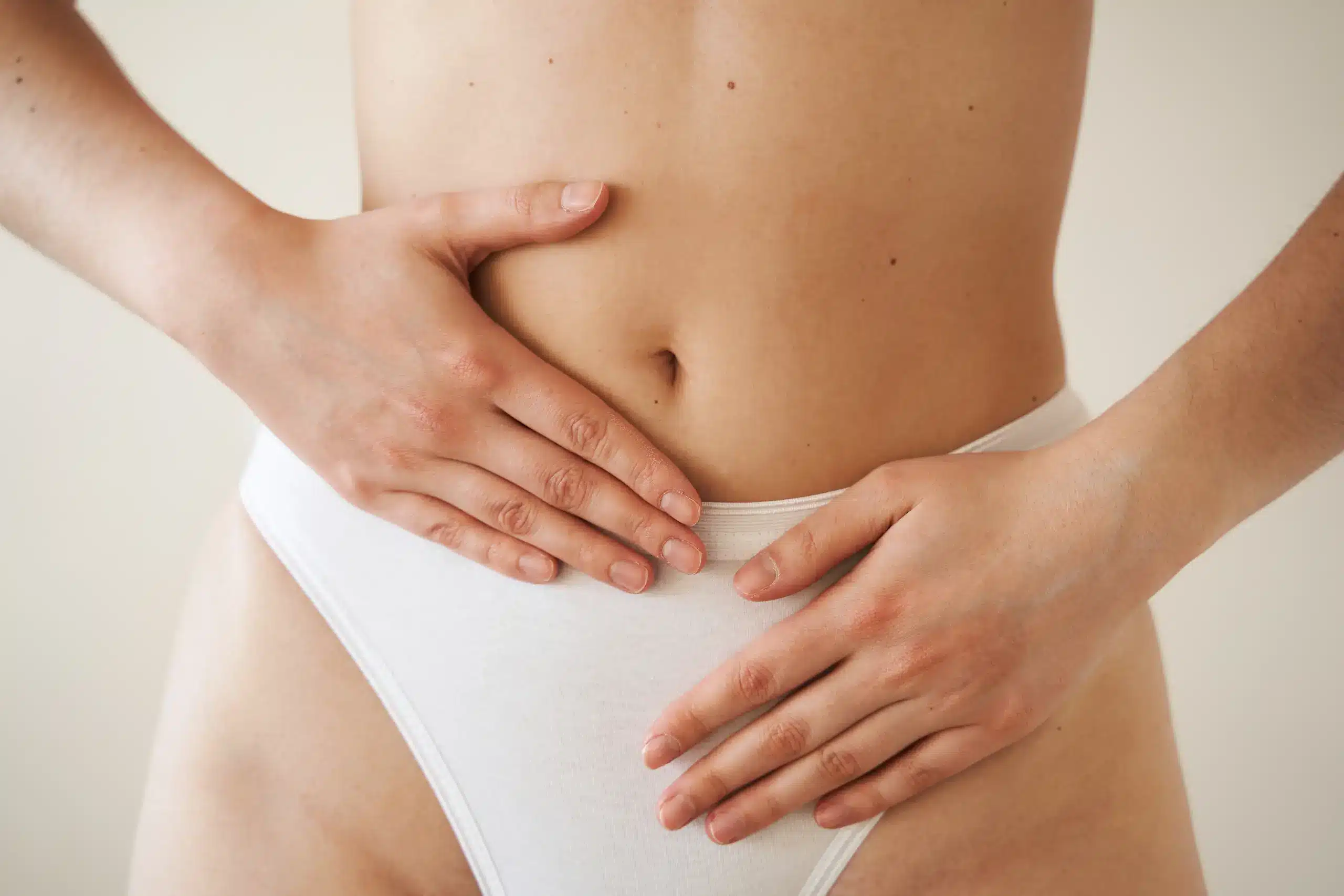 "Close-up of a woman’s midsection with hands gently resting on her lower abdomen, representing mindfulness, comfort, and proactive care for pelvic & vaginal health, often related to gynecological wellness and hormonal balance at Seashore MD in Little Silver, NJ.