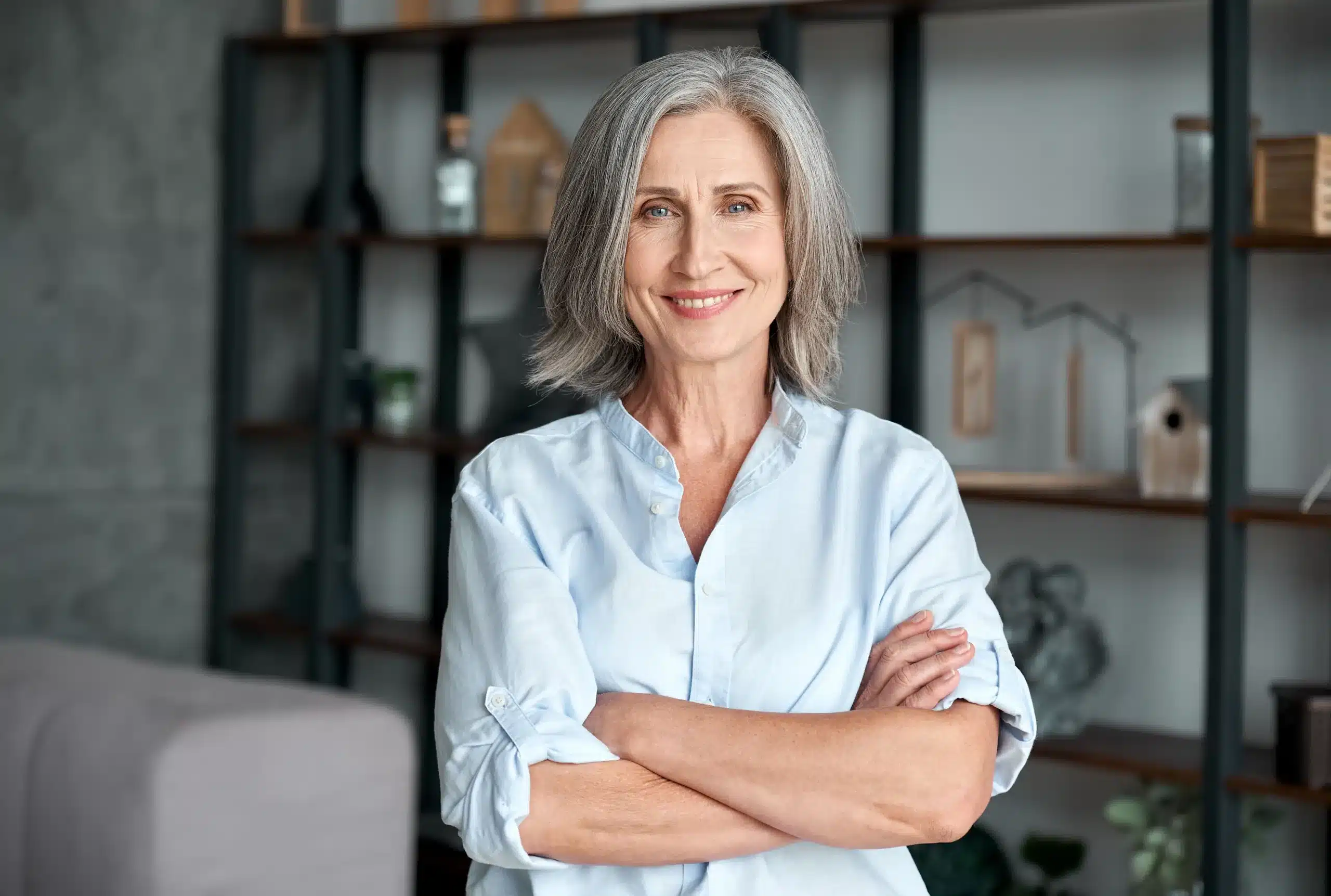 Confident mature woman smiling with arms crossed, representing balance, strength, and wellness during menopause management at Seashore MD in Little Silver, NJ.